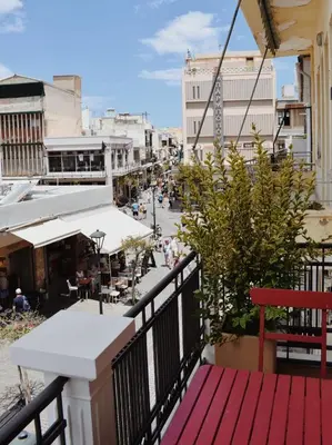 a balcony with a red bench on a city street at Kale Kapi City Living in Chania Town