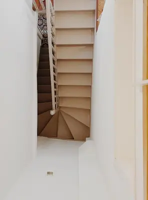 a spiral staircase in a white building with a window at Kale Kapi City Living in Chania Town