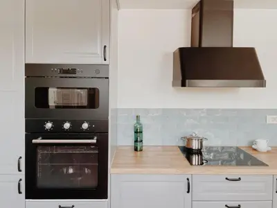 a kitchen with a stove top oven and a microwave at Kale Kapi City Living in Chania Town