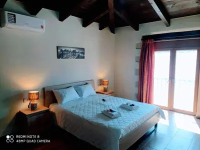 a bedroom with a bed with two lamps and a window at Traditional Villa in Pemonia in Pemónia