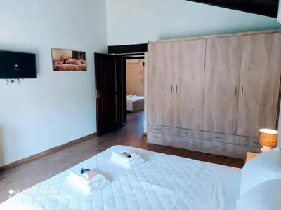 a bedroom with a white bed and a wooden cabinet at Traditional Villa in Pemonia in Pemónia