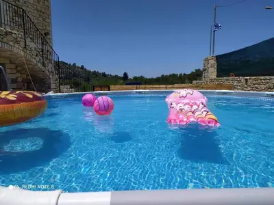 a swimming pool with two balls and a pink octopus at Traditional Villa in Pemonia in Pemónia