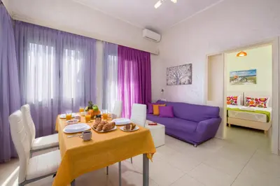 a living room with a table and a purple couch at Erontas Apartment in Palaiochóra