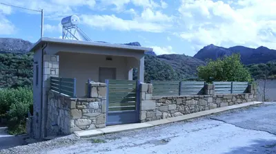 a small building with a stone wall and a water meter at Mouri Village in Aïkiryiánnis