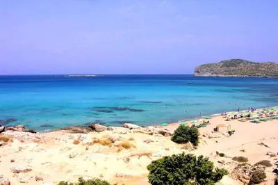 a beach with a group of people and the ocean at Mouri Village in Aïkiryiánnis