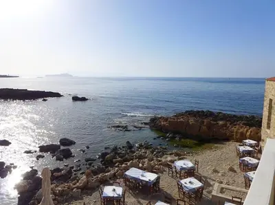 a group of tables and chairs on a rocky beach at FOS - casa casa group in Chania Town