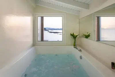 a bathroom with a bath tub with two windows at FOS - casa casa group in Chania Town