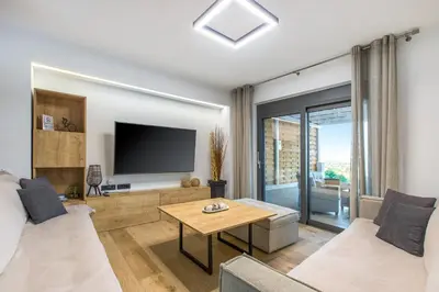 a living room with a television and a table at Casa Galatas in Galatás