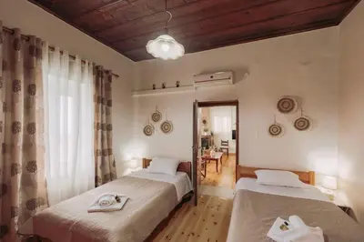a bedroom with two beds and a table and a mirror at The Morus House with Private pool in Melidhónion