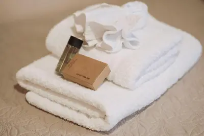 a pile of towels with a bottle of cosmetics on them at The Morus House with Private pool in Melidhónion
