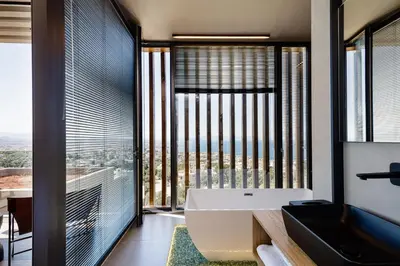 a bathroom with a tub and a large window at Omma Villas in Chania Town