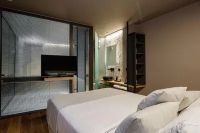 a bedroom with a bed and a flat screen tv at Omma Villas in Chania Town