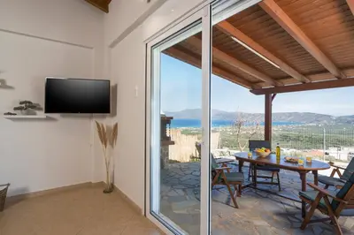 a dining room with a table and a view of the ocean at Villa Cleronomia, private pool, seaview, in Kaloudhianá