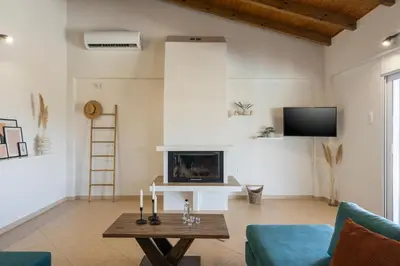 a living room with a fireplace and a table at Villa Cleronomia, private pool, seaview, in Kaloudhianá
