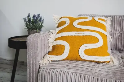 an orange and white pillow sitting on a couch at D&G Lux Flat City View next to Old Town & Market in Chania Town