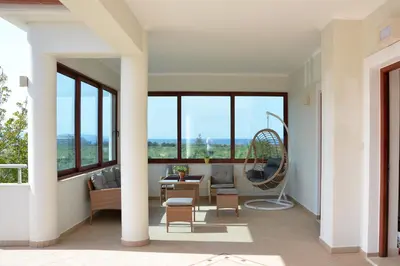 a living room with large windows and a couch at Ianthe Apartment in Kissamos