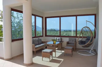 a living room with a chair and a swing at Ianthe Apartment in Kissamos
