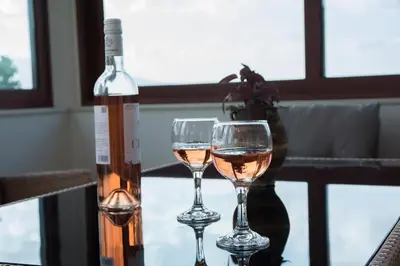 two glasses of white wine next to a bottle of wine at Ianthe Apartment in Kissamos