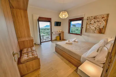 a bedroom with a bed and a couch and a window at Ianthe Apartment in Kissamos