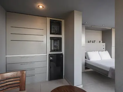 a small bedroom with a bed and a refrigerator at VILLA NIBA in Kalathas