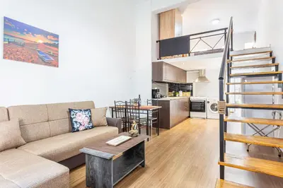 a living room with a couch and a stair case at Neva's Apartment's in Center Chania 1 2 in Chania Town