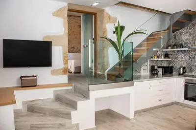 a living room with a staircase and a tv at Casa Piedra in Nohia