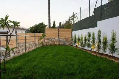 a garden with a retaining wall and green grass at Casa Piedra in Nohia