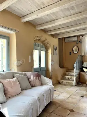 a living room with a white couch in front of a door at Maison Théia, entre mer et montagne Samonas in Samonás