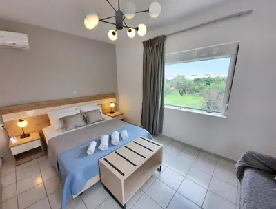 a bedroom with a large bed and a window at Stelios Studios Sougia in Sougia