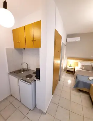 a bathroom with a sink and a bed in a room at Stelios Studios Sougia in Sougia