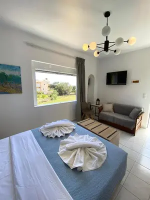 a bedroom with a bed and a living room with a couch at Stelios Studios Sougia in Sougia
