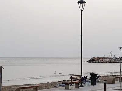a bench and a street light on the beach at Sea U in Chania Town