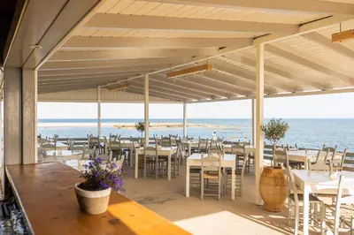 a restaurant with tables and chairs on the beach at Mylos Seaside Experience in Frangokastello