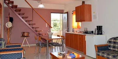 a kitchen and living room with a staircase and a table at Anestis Ioanna Villa in Daratso