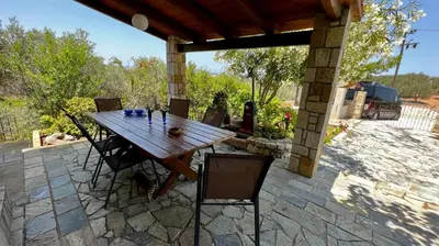 a wooden table and chairs on a patio at Anestis Ioanna Villa in Daratso