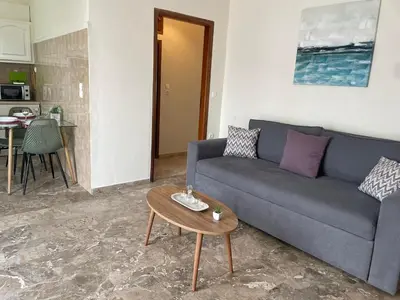a living room with a blue couch and a table at Chania Nice Apartment 3 in Chania Town
