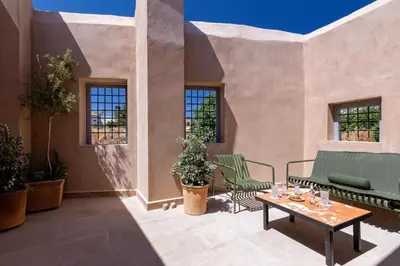 a patio with two chairs and a table and windows at AZADE Chania in Chania Town