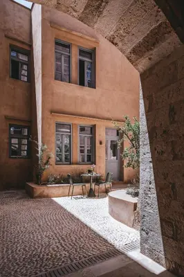 a building with chairs and a table in front of it at AZADE Chania in Chania Town