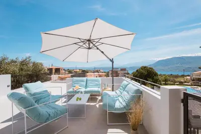 a patio with chairs and an umbrella on a balcony at Hermes&Dione in Argoulidhés