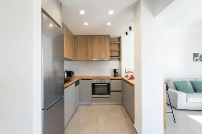 a small kitchen with white walls and wooden cabinets at Hermes&Dione in Argoulidhés