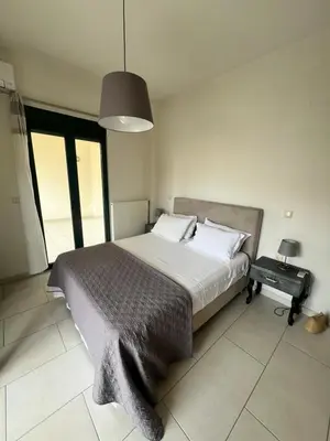 a bedroom with a large bed and a table at Zoi’s Apartment in Chania Town