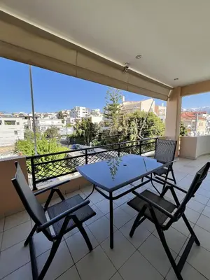 a table and chairs on a balcony with a view at Zoi’s Apartment in Chania Town