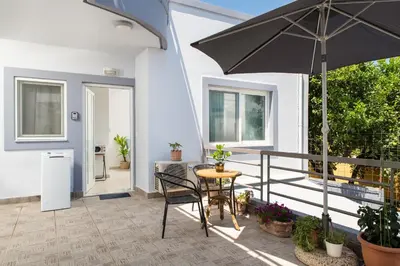 a patio with a table and an umbrella at ''Meraviglia casa'' Irida apartment in Chania Town