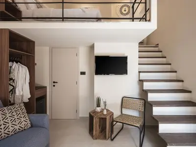 a living room with a staircase and a couch at Copal Experience The Port in Chania Town