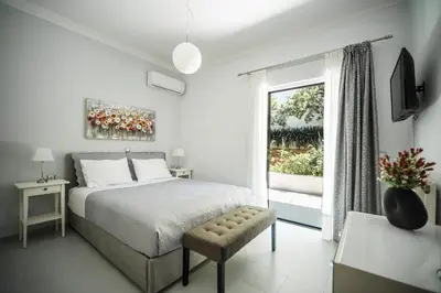 a white bedroom with a bed and a window at The Nest of Urban Living by 8essentially in Chania Town
