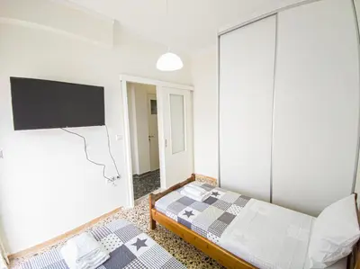 a bedroom with a bed and a flat screen tv at Fully renovated apartment close to the bus station and the city center! in Chania Town