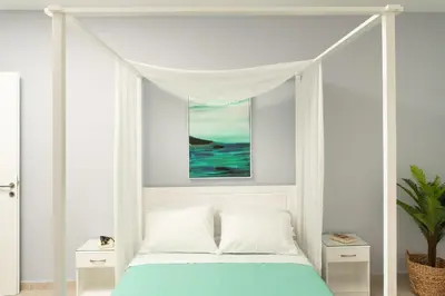 a white bed with a canopy in a bedroom at ''Meraviglia casa'' Ariadne in Kato Daratso