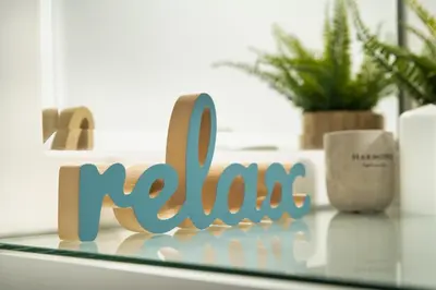 a wooden sign that says noosa on a glass table at ''Meraviglia casa'' Ariadne in Kato Daratso