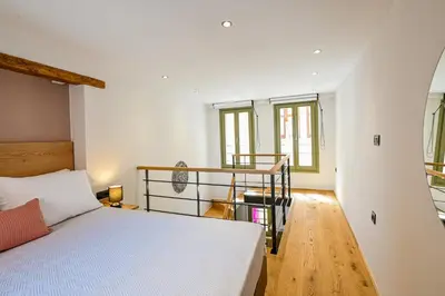 a bedroom with a bed and a staircase with windows at Nem Home, amazing 1 bedroom house in Chania Town