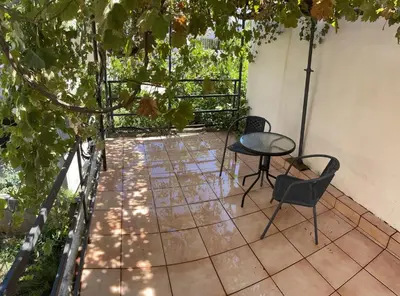 a patio with a table and chairs and trees at Mersini Apartment in Chania Town